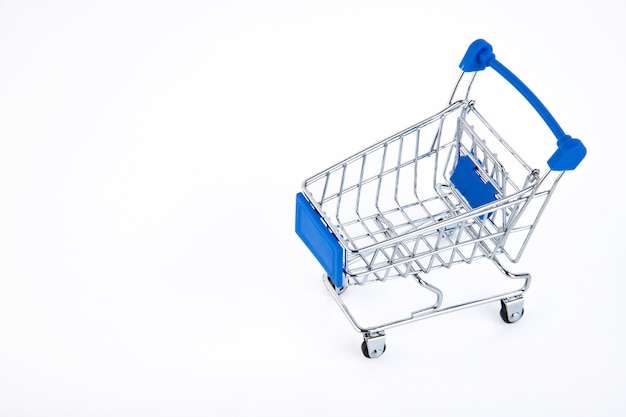 Shopping cart, e-commerce, digital commerce, retail on white surface.