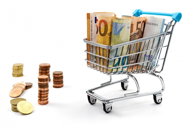 Shopping cart full of euro banknotes isolated on white.