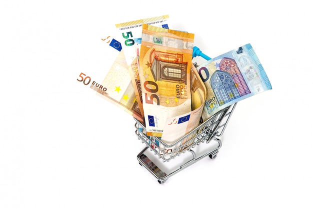 Shopping cart full of euro banknotes isolated on white.