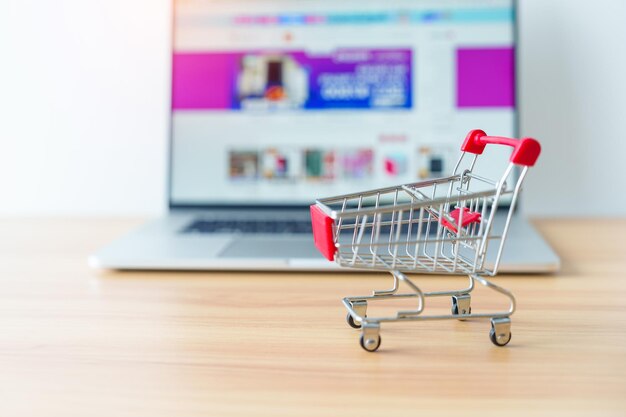 Shopping cart and laptop computer with marketplace website business technology ecommerce digital banking and online payment concept