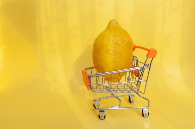 Shopping cart with fruits. bright yellow juicy lemon in a toy shopping cart for products