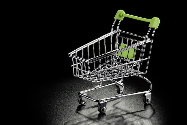 Shopping cart with green handle on a black background