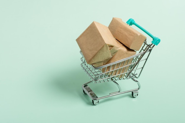 Shopping cart with package boxes on green background