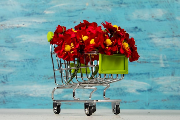 Shopping cart with red artificial flowers