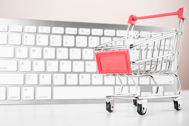 Shopping cart with white keyboard on background