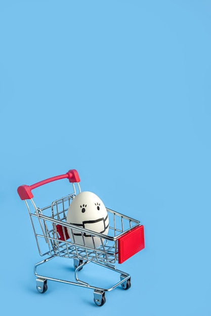 Shopping cart with a white mask with painted mask on blue background.