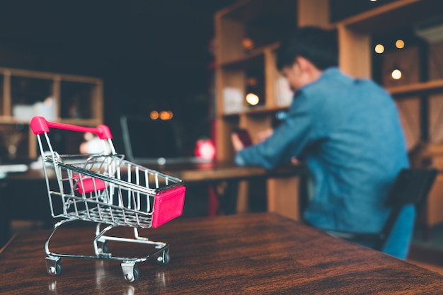 Shopping cart on wooden table in shop, Online shopping and ecommerce concept.