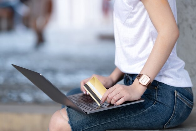 Shopping girls holding credit card are using laptop.