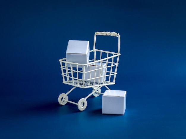 Shopping online business ecommerce delivery purchasing power concepts White parcel boxes in shopping trolley cart supermarket isolated on blue background minimal style