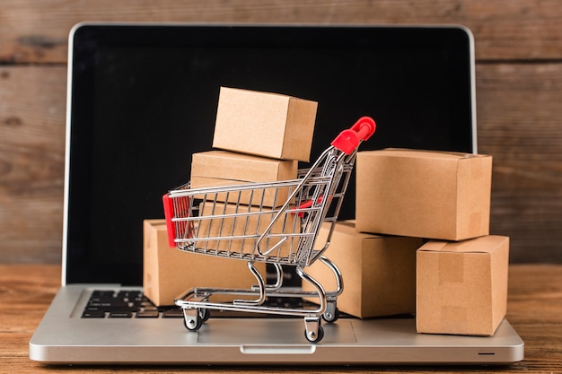 Shopping online at home concept. Cartons in a shopping cart on a laptop keyboard.