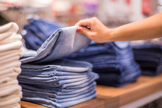 Shopping sale background theme. Jeans clothes on hanger in shop.