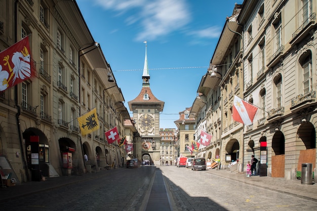 Shopping street with clock tower Zytgloggein the old medieval city of Bern, Switzerland.