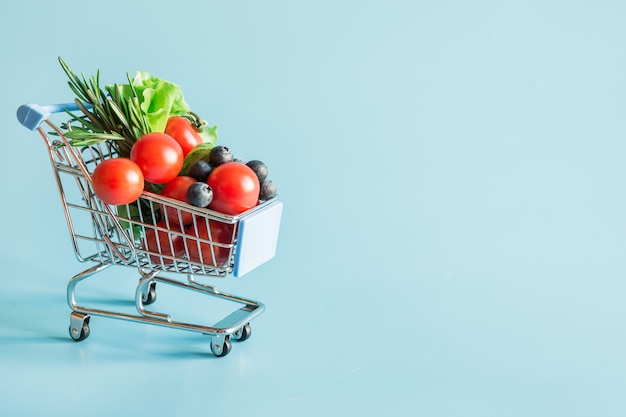 Shopping trolley full of fresh vegetables groceries 