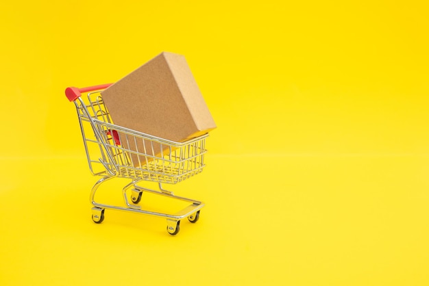 Shopping trolley with cardboard box. Copy space for promo text