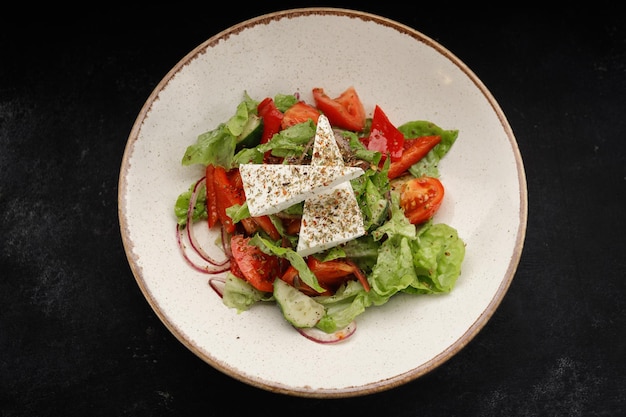 Shopsky salad with cheese and vegetables on a white plate