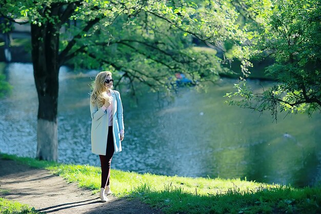 shore pond park adult girl / walk in city park, beautiful girl near pond in urban outdoor recreation area