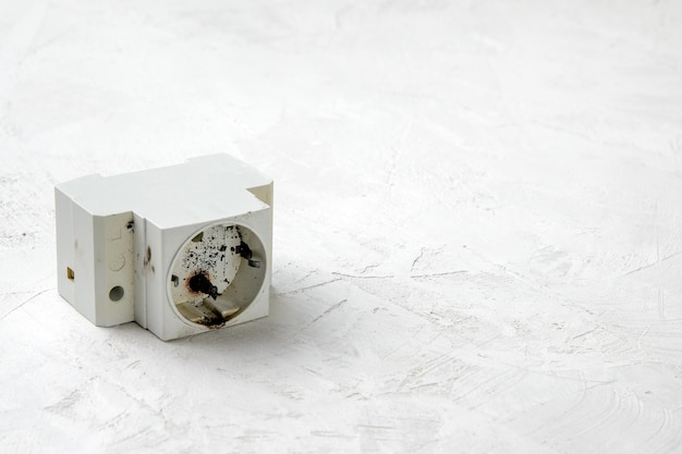 Short circuit in electrical outlet gray concrete background copy space