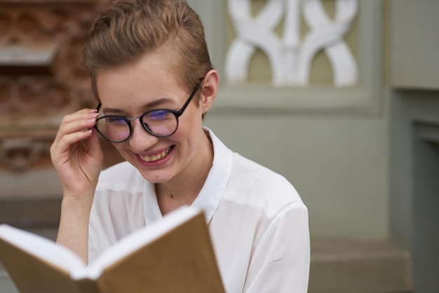 Short haired woman with glasses walking around the city with a book Lifestyle