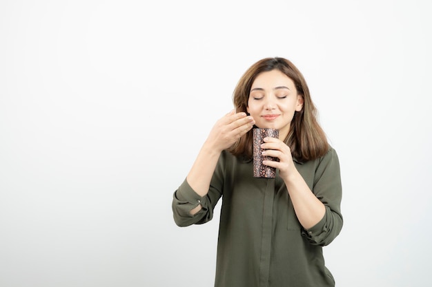 Short-haired young girl with cup of latte standing and posing. High quality photo