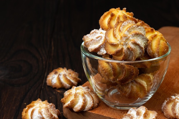 shortbread cookies on a dark wood table in a glass cup