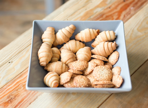 Shortbread cookies in the form of bagels on a gray plate on a wooden table