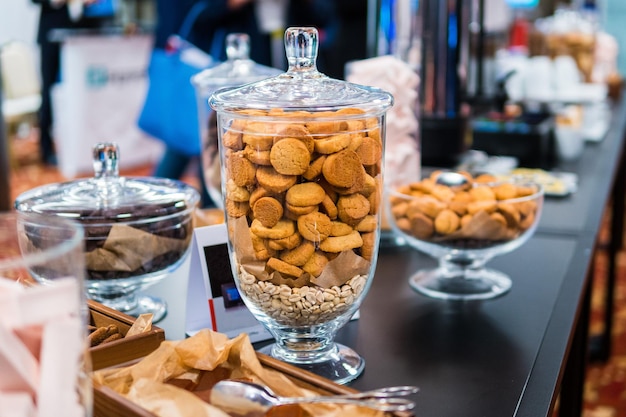 Shortbread cookies in glassware and other sweets on the buffet table during the coffee break