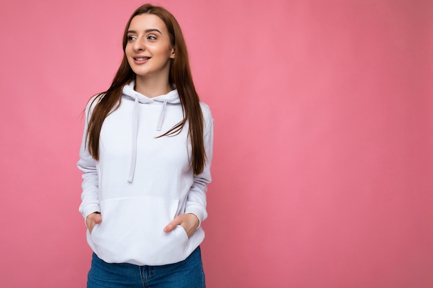 Shot of attractive happy smiling young woman wearing casual outfit standing isolated over colourful