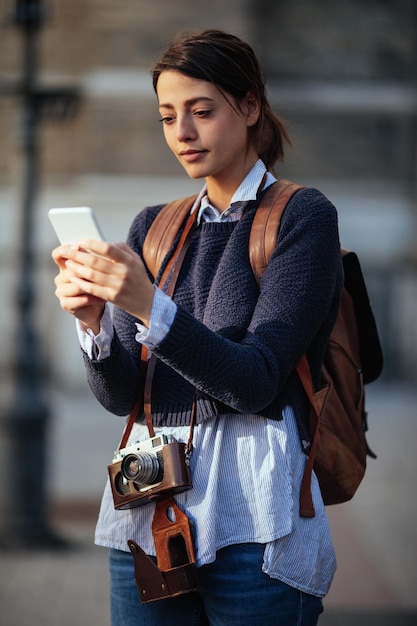 Shot of an attractive young woman using a mobile map while sightseeing in a foreign city