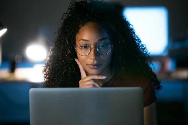 Shot of confident young business woman working with laptop sitting in the office.