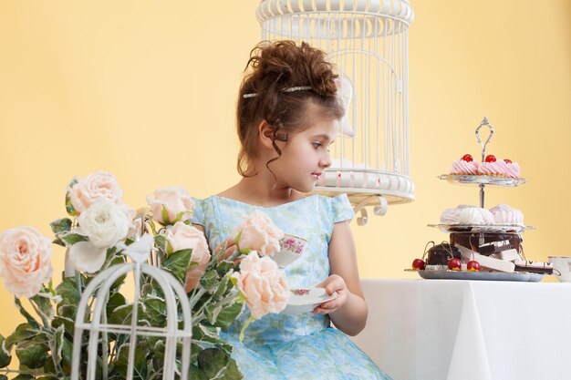 Shot of cute little lady drinking tea in studio