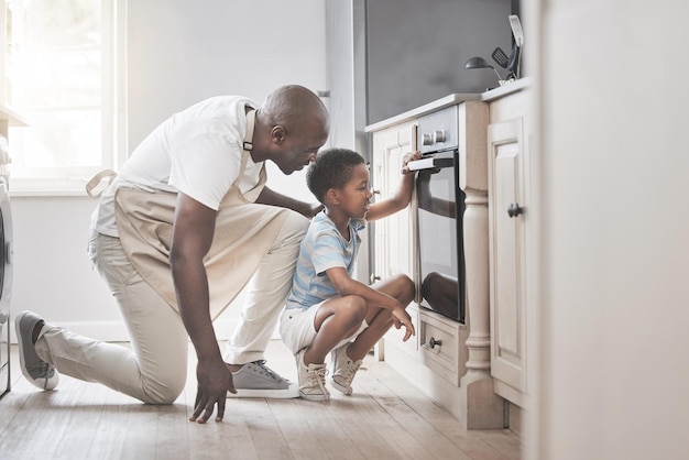 Shot of a father and son standing by the oven in the kitchen