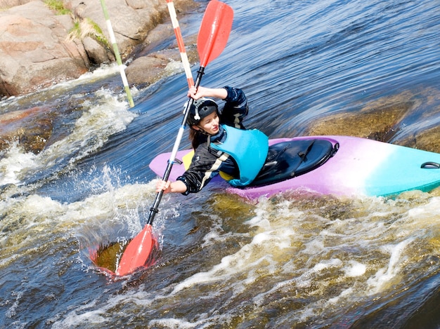 A shot of the female kayaker on the rough water