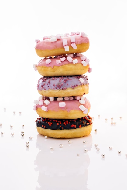 Shot of five sweet doughnuts stacked on top of each other in the form of a tower tasty delicious swe