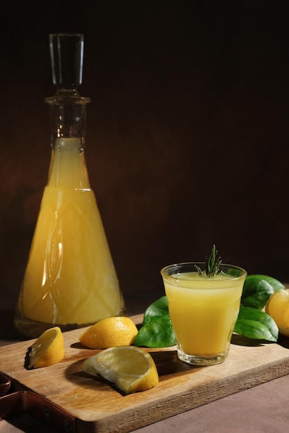 Shot glass of Italian lemon liqour lemons and limoncello decanter