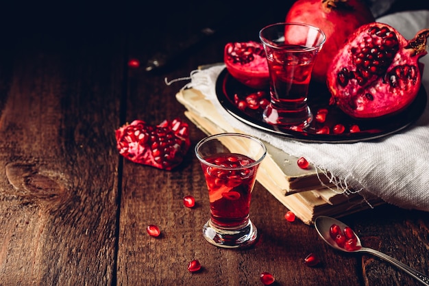 Shot glass of pomegranate cocktail with vodka, juice and fresh fruits