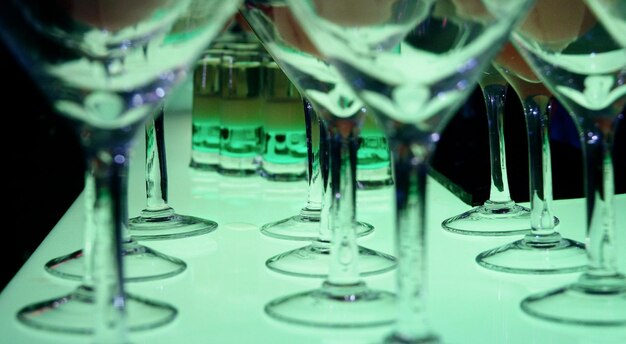 Shot glasses with cocktails between martini glasses on the bar counter