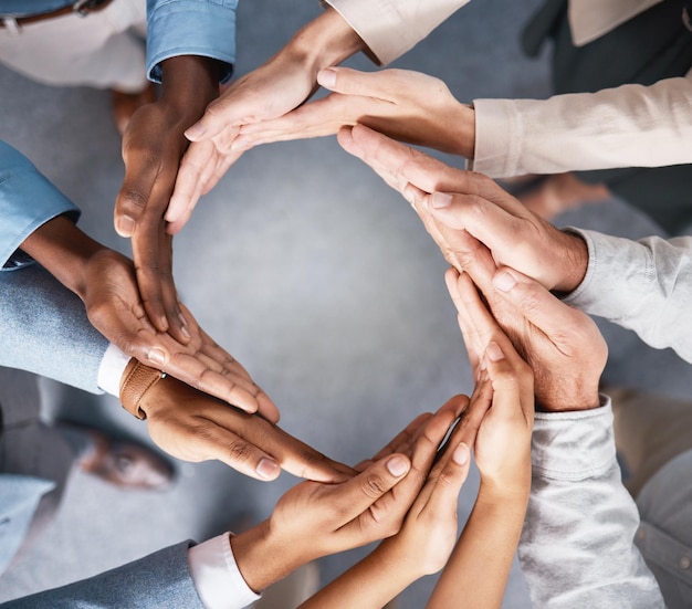 Shot of a group of businesspeople joining hands in solidarity