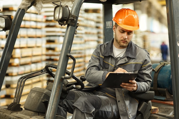 Shot of a handsome bearded young male engineer filling documents sitting