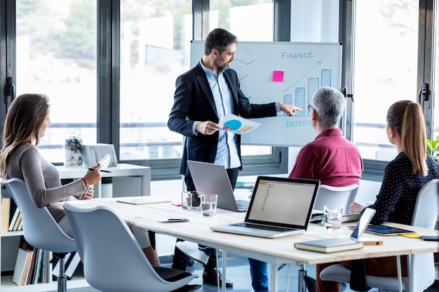 Shot of handsome businessman explaining a project to his colleagues on coworking place.