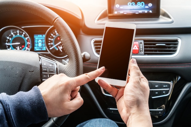 Shot of a handsome man using mobile phone while driving.