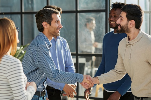 Shot of a happy businessman welcoming his new colleague to the team during a meeting in the boardroo