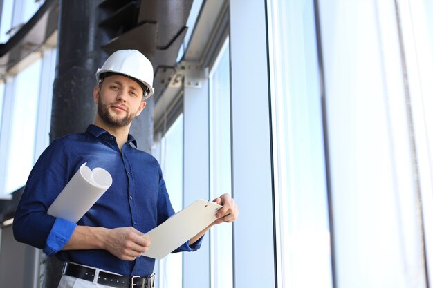 Shot of male architect wearing hardhat and inspecting new building.