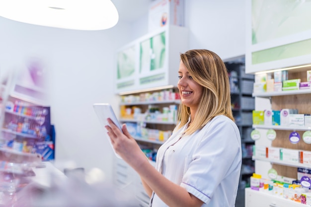 Shot of a pharmacist working using a digital tablet looking at the shelves at the drugstor