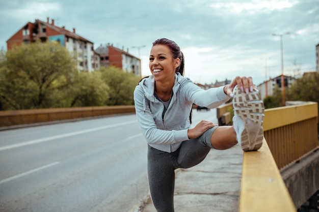 Shot of a smiling young woman doing stretching exercises.