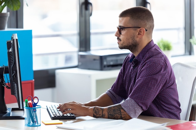 Shot of software developer working with computer in the modern startup office.