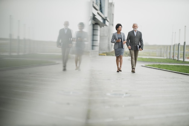 Shot of two successful multi-ethnic business people walking in front of the office building.