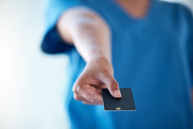 Shot of an unrecognisable doctor showing you a credit card