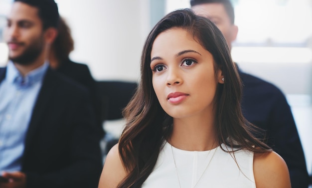 Shot of a young businesswoman sitting in the audience of a business conference