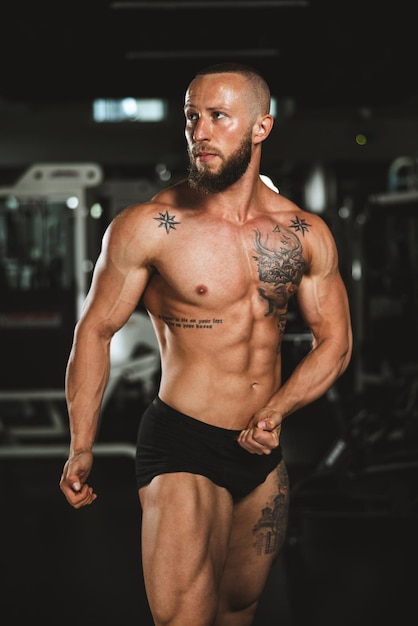 Shot of a young muscular bodybuilder showing his perfect muscles while posing after working out at the gym.