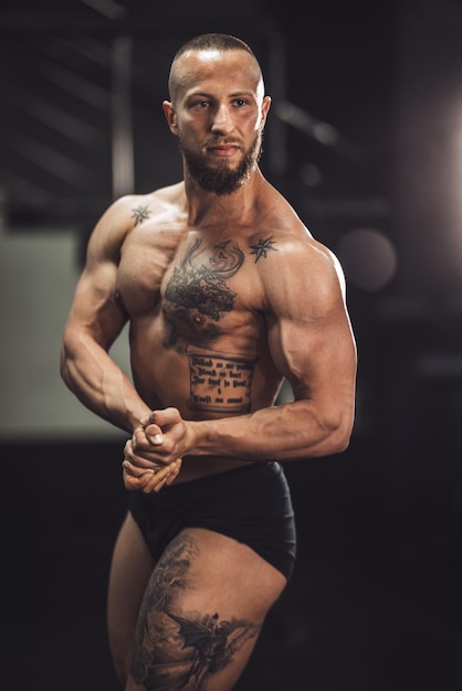 Shot of a young muscular bodybuilder showing his perfect muscles while posing after working out at the gym.